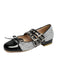Chaussure plate noire et argentée à paillettes avec boucles sur fond blanc