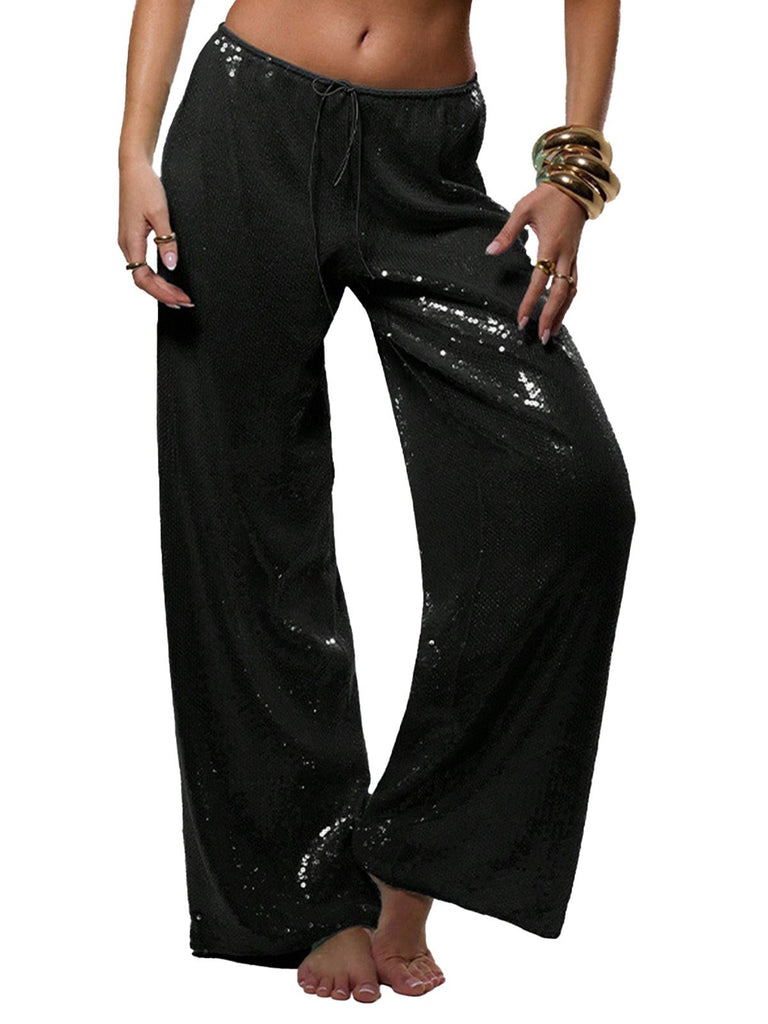 Pantalon à paillettes noires porté par une personne sur fond blanc