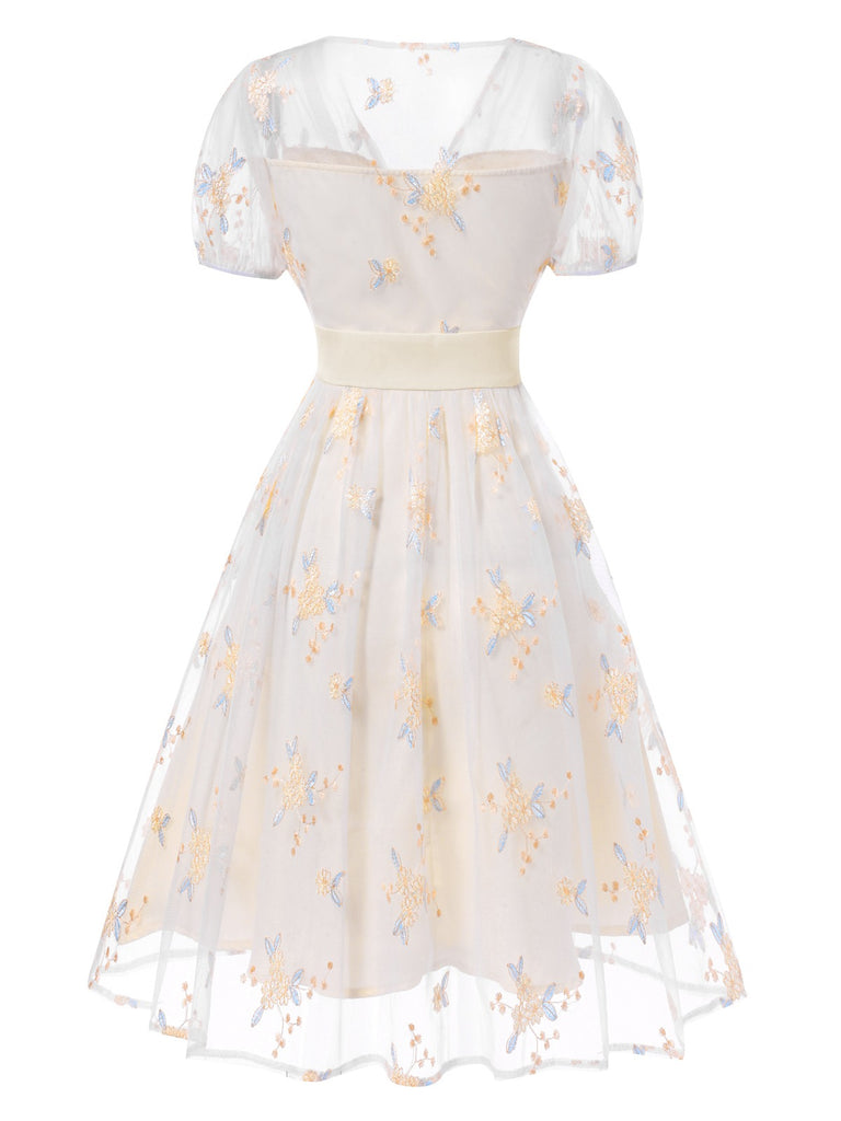 Robe blanche à fleurs brodées col V profond années 1950