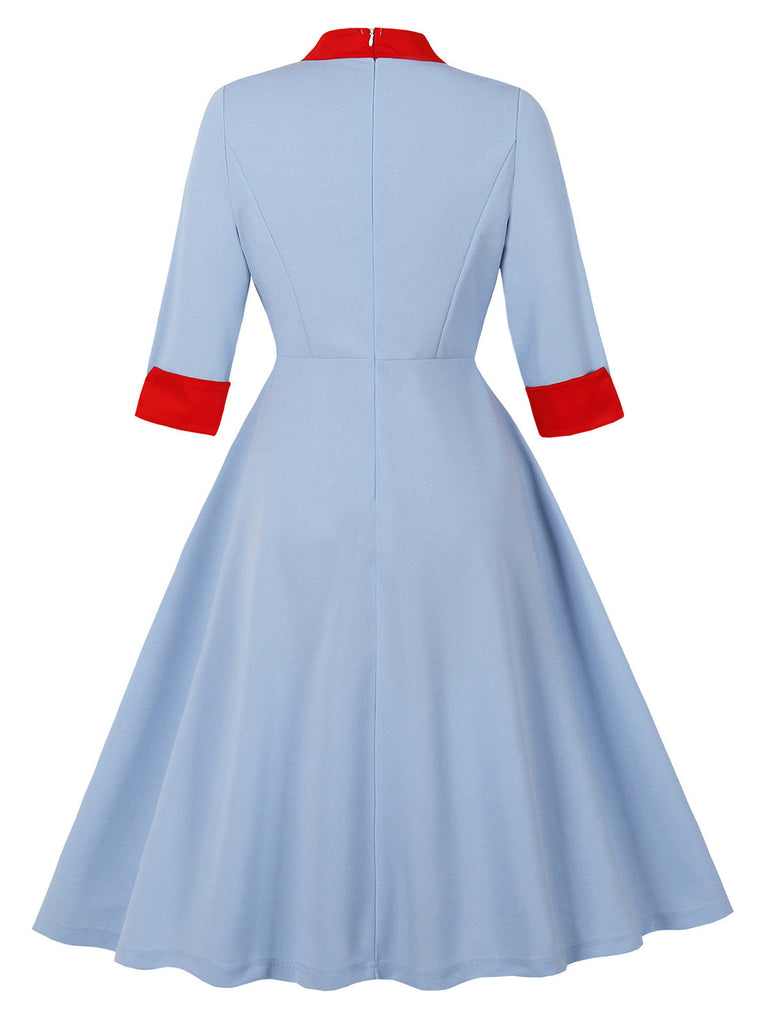Robe bleue col montant et nœud contrastant années 1950