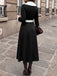 Robe noire et blanche à revers, col V et manches longues années 1950