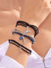 Multiple bracelets with charms on a wrist against a light background