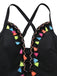 Close-up of the vibrant, multi-colored tassels and intricate embroidery along the deep V-neckline.