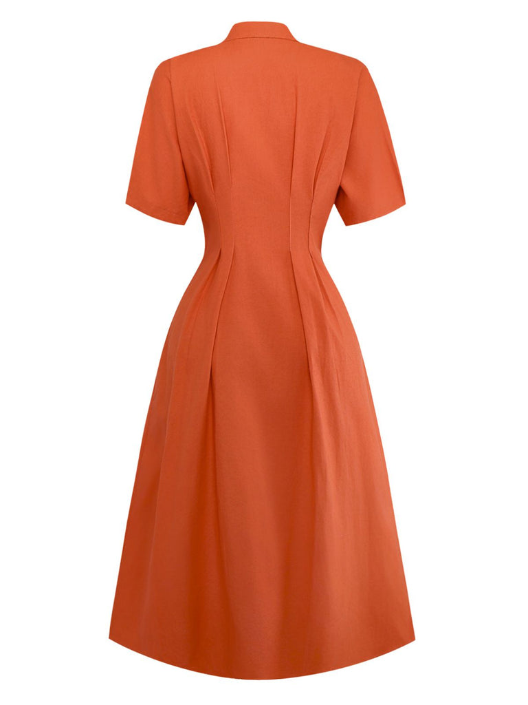 Robe unie orange à col en V et boutons et broche années 1940
