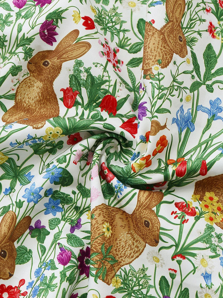 A swirled view of the fabric highlighting the soft texture and the vibrant, intricate bunny and botanical design.