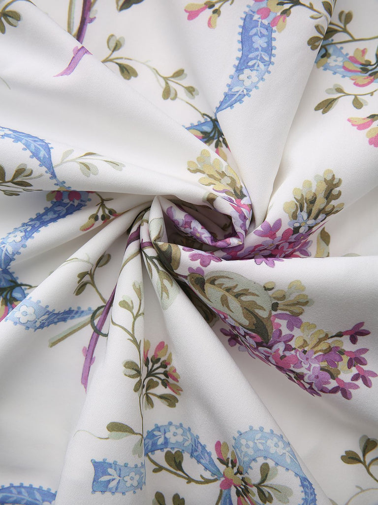 A swirled view of the white fabric showcasing the soft texture and vibrant botanical print.