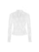Detailed view of the white floral lace long-sleeve top paired with a black jumpsuit.